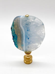 Blue agate mineral lamp finial with natural banding and translucent crystal patterns on a knurled brass fitting
