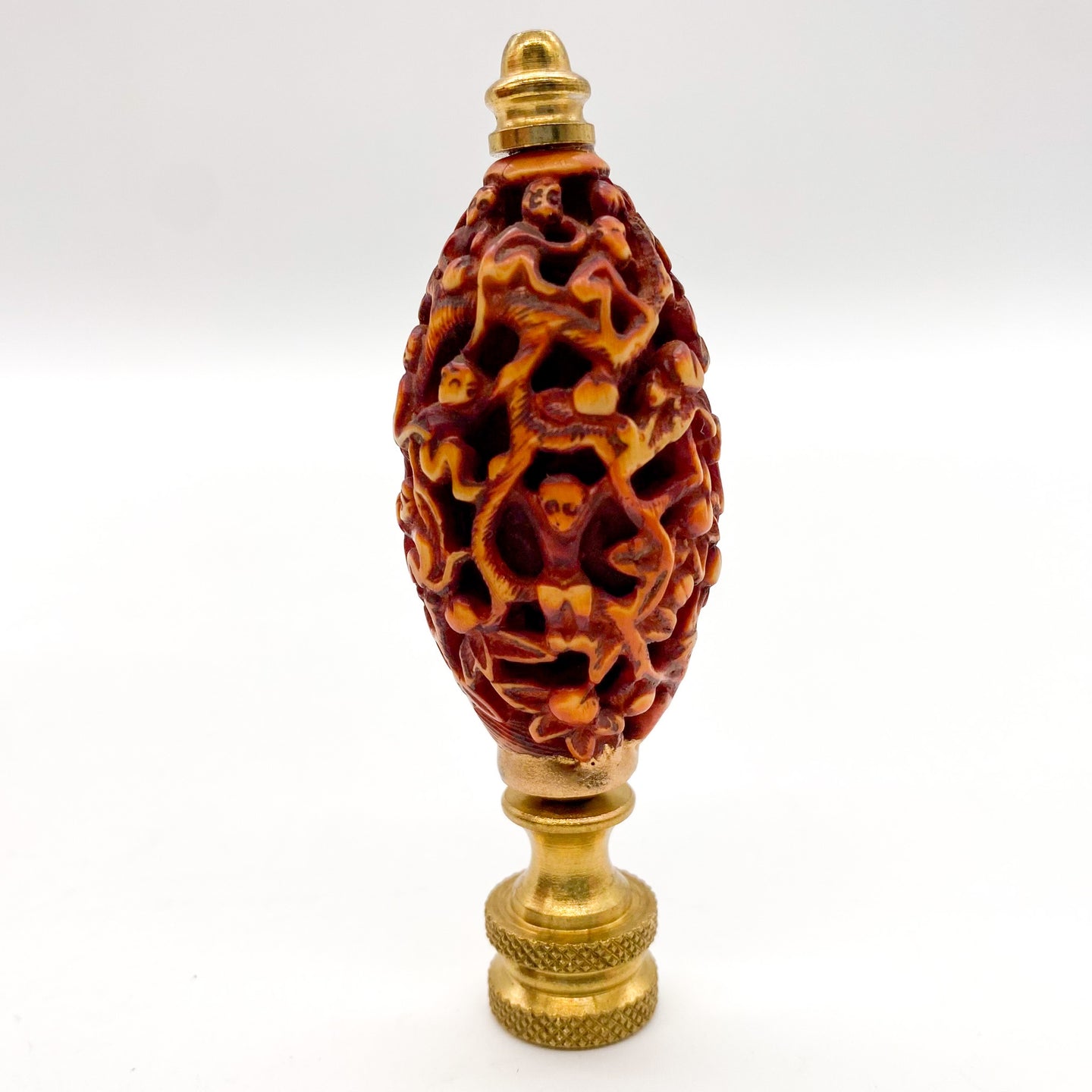 brown carved root wood finial depicting monkeys in a tree
