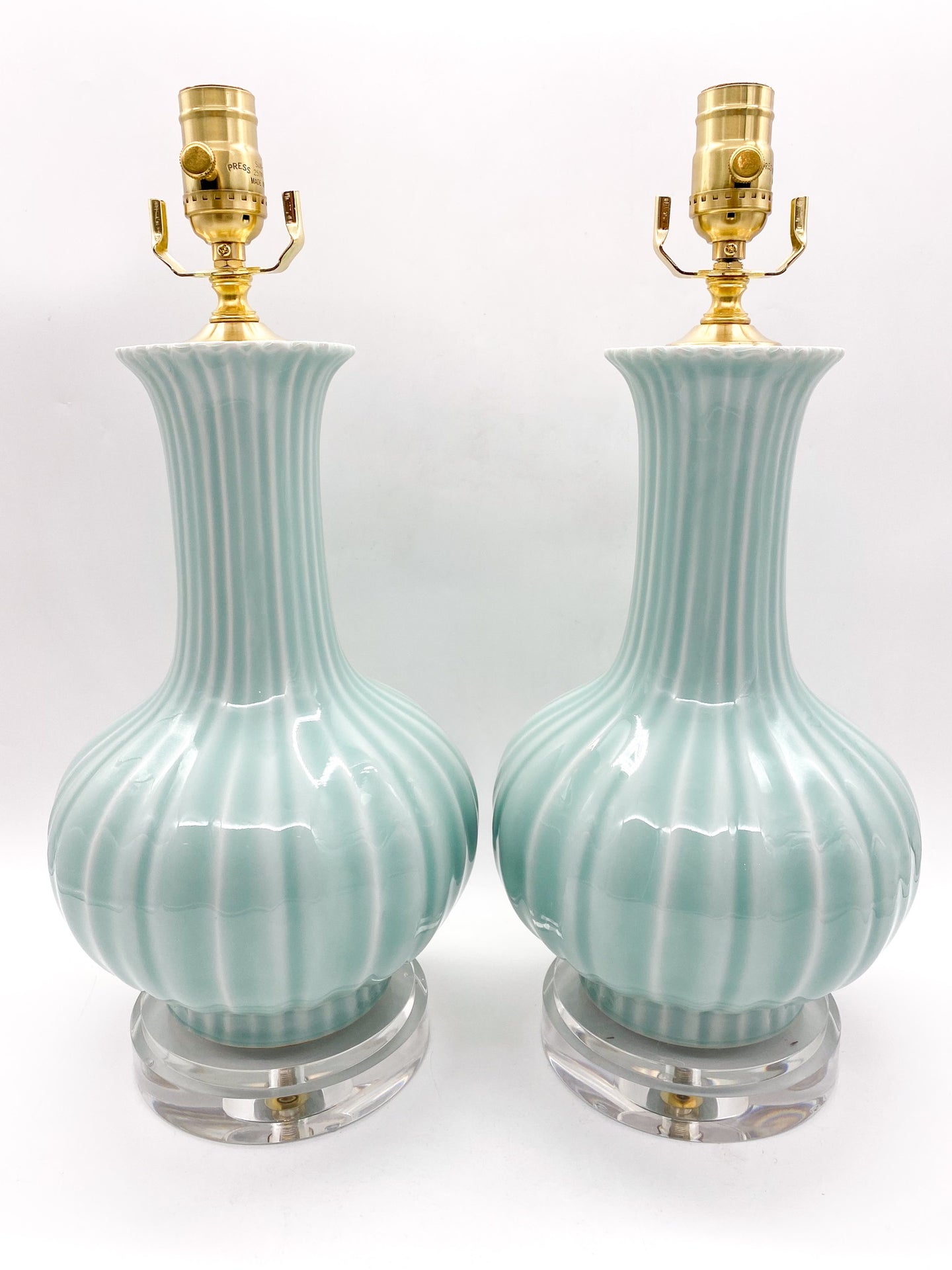 Pair of celadon minty green ceramic table lamps with gold accents on clear acrylic graduated bases 24